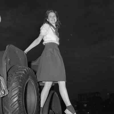 Girl standing on the side of a command car