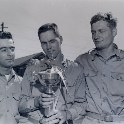 Three soldiers with a baseball trophy