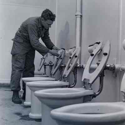 Soldier replacing toilet paper in bathroom