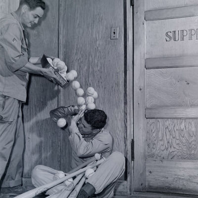 Soldier pouring baseballs on another soldier