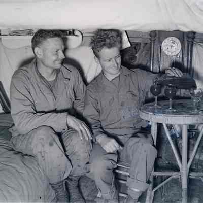 Soldiers pouring wine in a dugout in Anzio