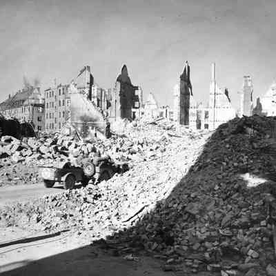 Jeep full of soldiers drives through rubble