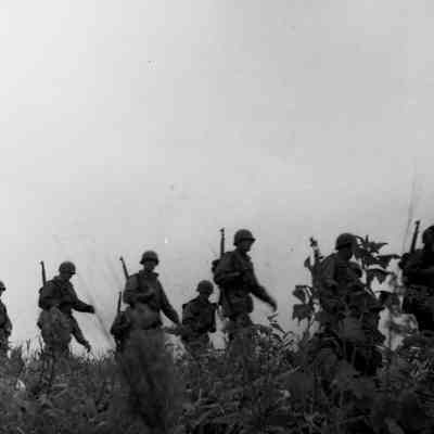 Soldiers marching through a field