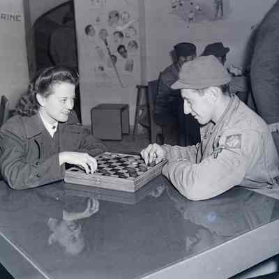 Red Cross girl playing checkers with a soldier