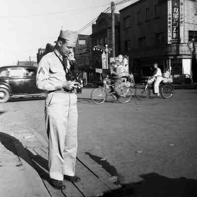 Soldier taking a picture on a Sapporo street corner