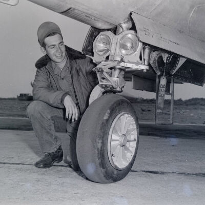 Air Force airman examining nose wheel of an aircraft