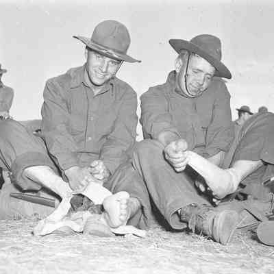 Soldiers removing their shoes and socks during inspection