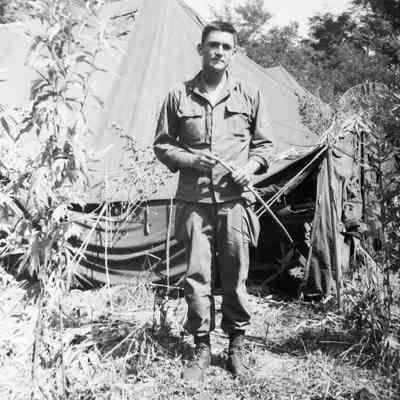 Soldier standing in front of tents
