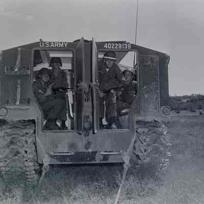 Soldiers looking out the back of an M-75 armored personnel carrier