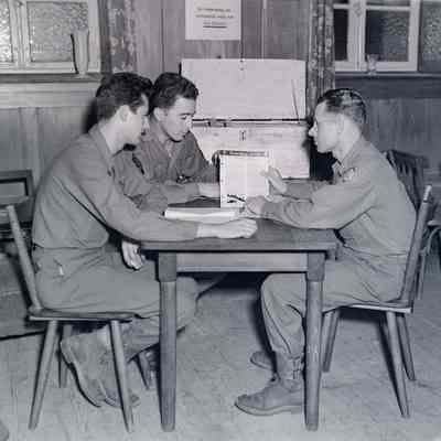 Two soldiers listening to an officer explain civilian job opportunities
