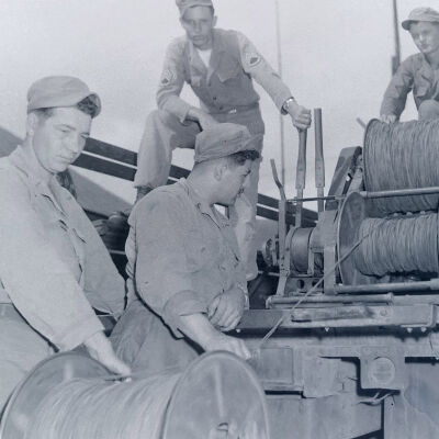 Soldiers spooling commo wire into back of truck
