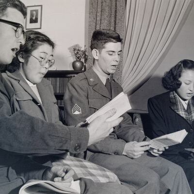 Two soldiers and two Japanese women singing together