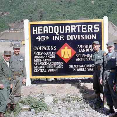 Soldiers standing in front of sign