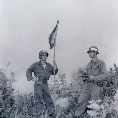 Soldiers standing with signal flag and smoke