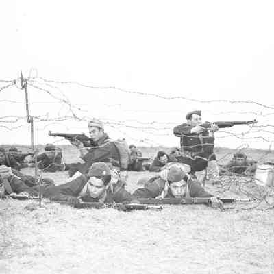 Soldiers practicing low crawl under barbed wire