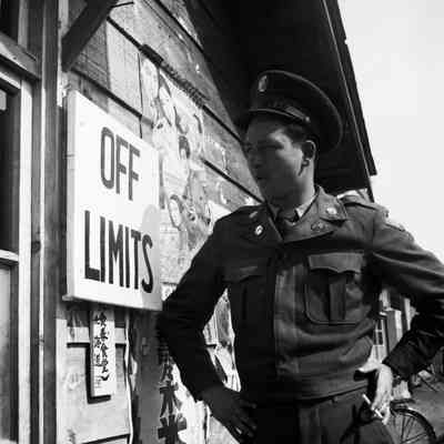 Soldier staring at a building posted "Off Limits"