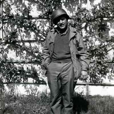 Soldier standing in front of ivy-covered wall