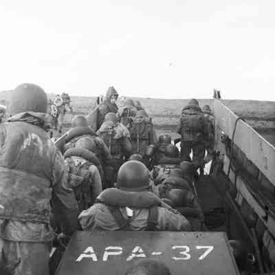 Soldiers landing on beach from landing craft