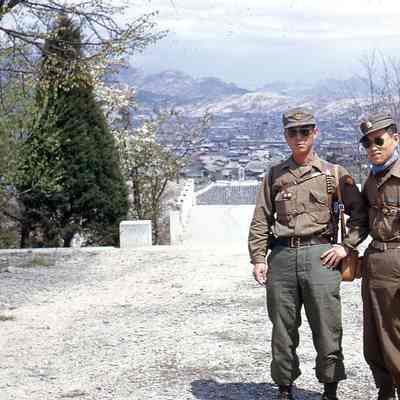 Two soldiers posing with mountains in background