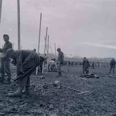 Soldiers and German prisoners working on a fence