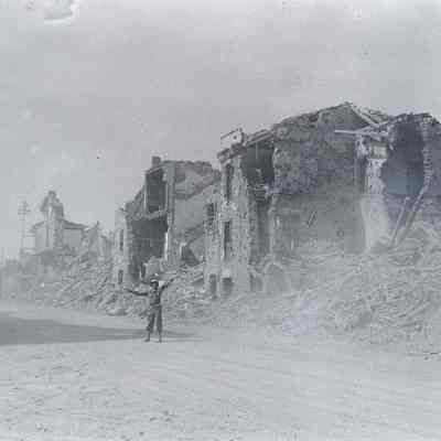 Soldier on road in front of destroyed buildings