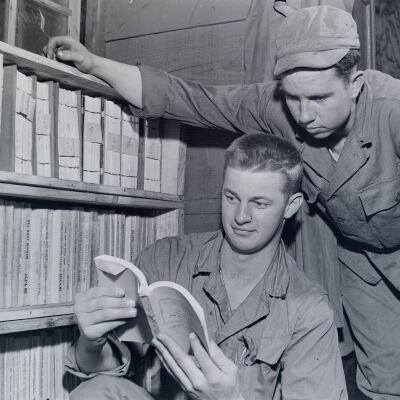 Soldiers reading a technical manual in a library