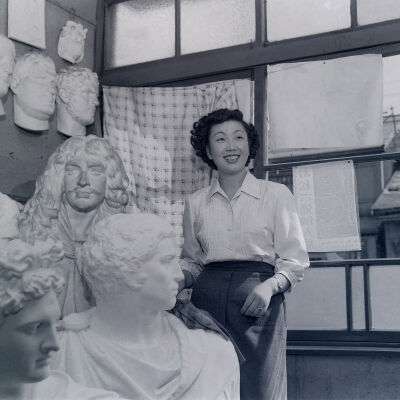 Japanese woman in a studio filled with plaster busts