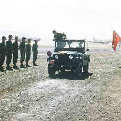 General reviewing soldiers from a jeep