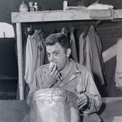 Solider eating over a large bucket