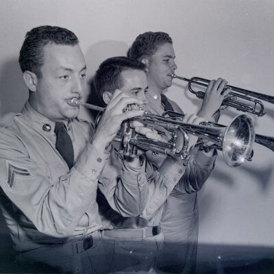Three soldiers playing trumpets