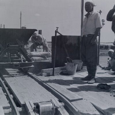 Japanese civilians using gondolas to mix concrete
