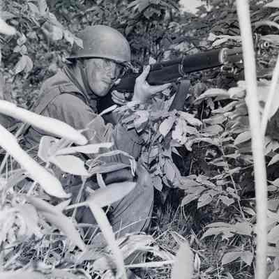 Soldier aiming his rifle from the bushes