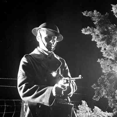 Night photo of soldier with his pistol drawn