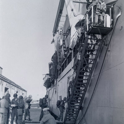 Soldiers with weapons and field gear boarding a troop ship