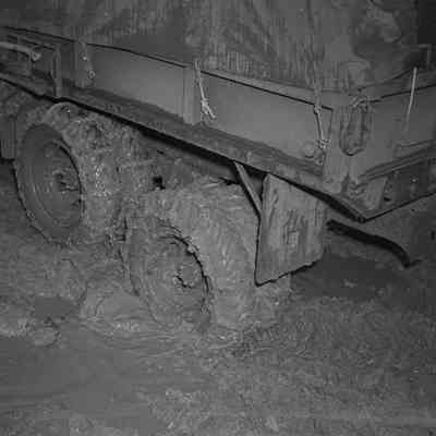 Rear wheels of military truck moving through mud