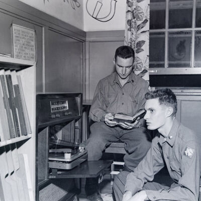 Soldiers reading and listening to a record player in the barracks