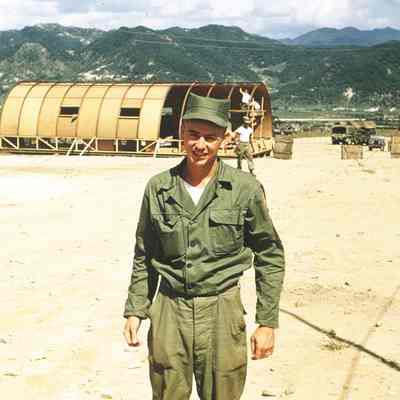 Aloysius (Al) Haverkamp in front of a Quonset hut under construction