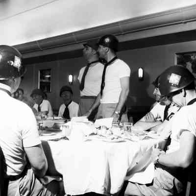 Soldiers in ties and helmets at dinner