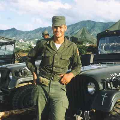 Soldier posing in front of Jeeps