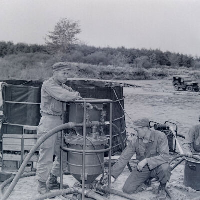 Soldiers operating a small water purification plant