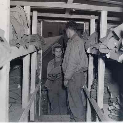 Soldier handing cleaned clothes to soldier