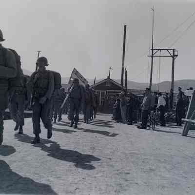 Soldiers marching through village