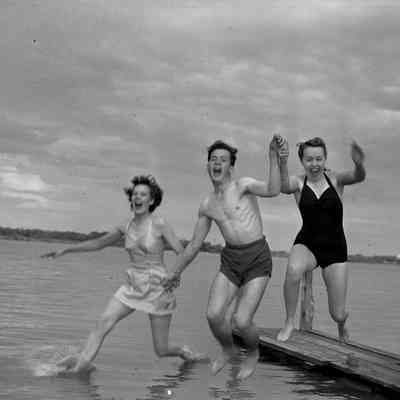 Soldier and two girls jumping off a dock