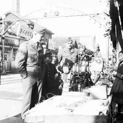 Soldiers watching a Japanese vendor