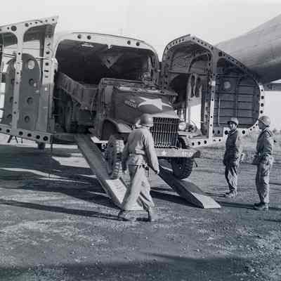 2 1/2T truck being loaded onto a C-119 cargo aircraft