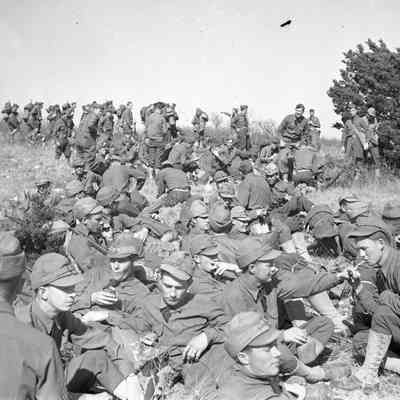 Soldiers in winter caps relaxing in the field