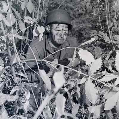 Soldier practicing concealment during field exercise