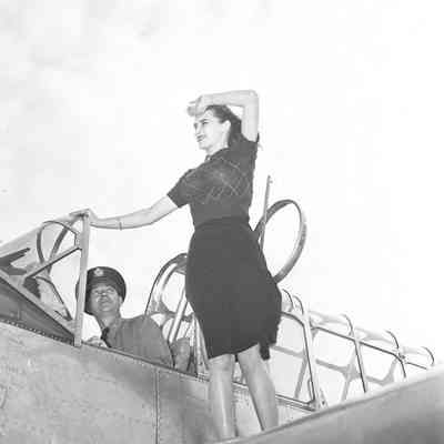 Woman posing on aircraft wing