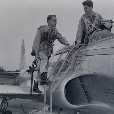 Pilots climbing into a P-80 fighter on flight line