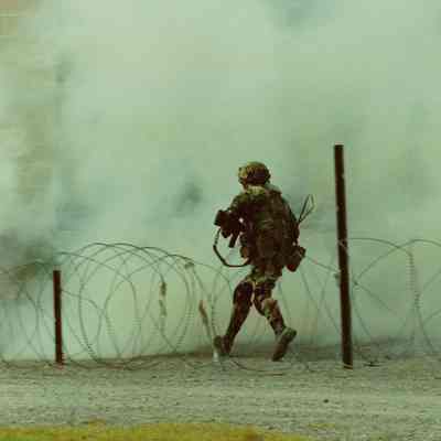 Soldier advancing through smoke in training village